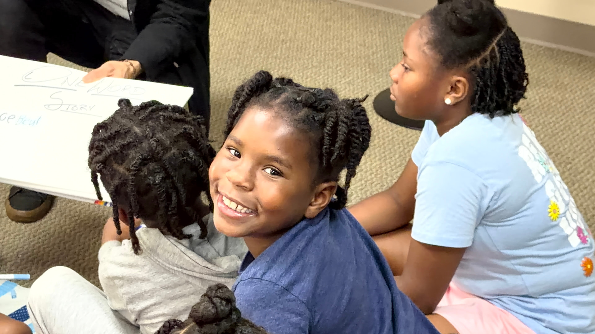 Young learners smiling during a One Word Story activity